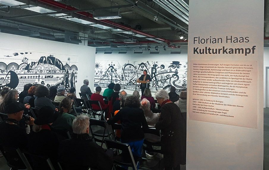 Gruppe menschen vor großformatiger wandarbeit width='300'